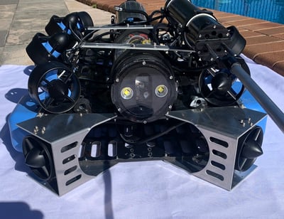 Black and blue custom ROV photographed beside a swimming pool.
