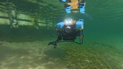 Blue underwater ROV operating beneath the surface in a test pool.