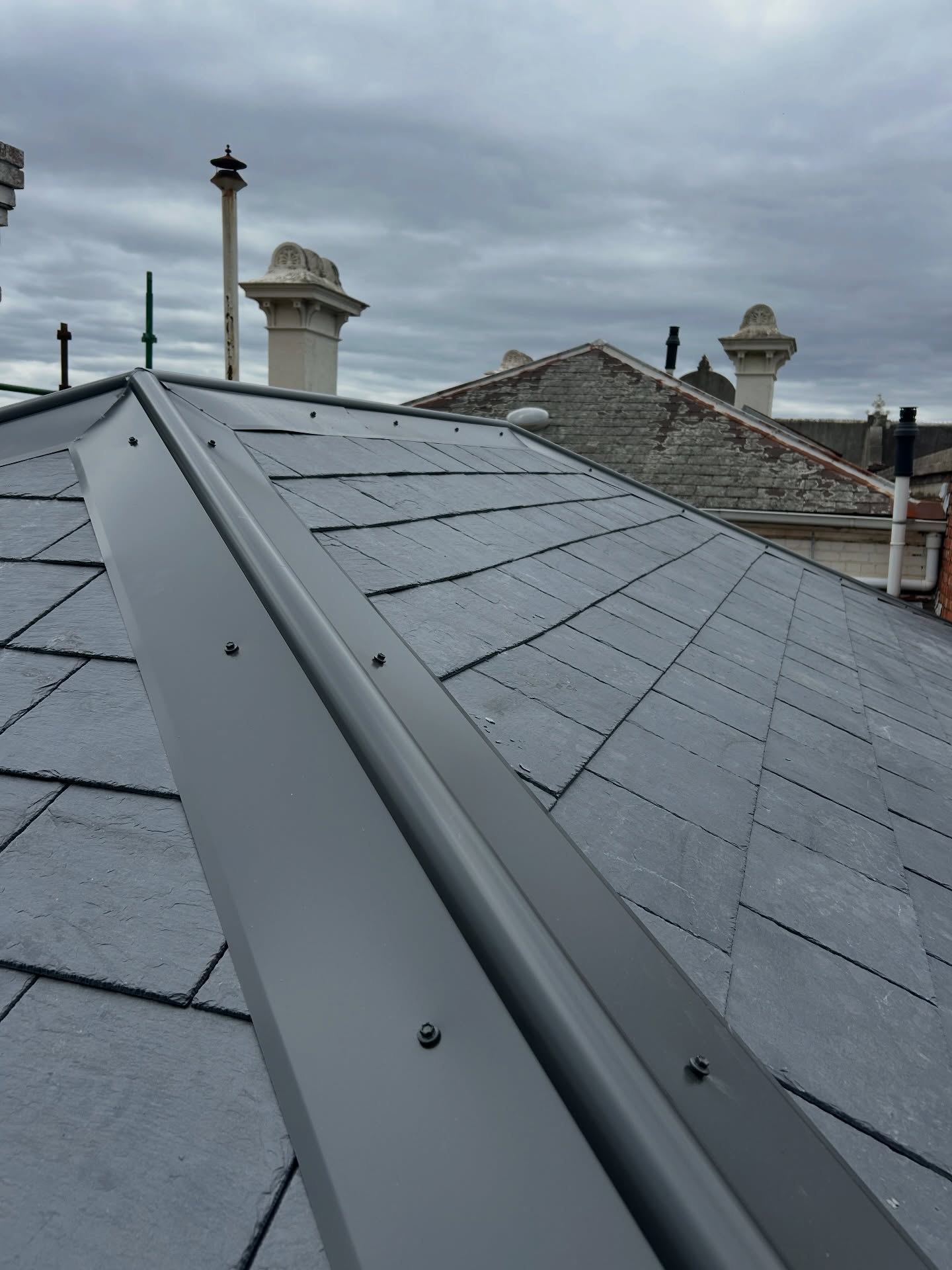 Reroof complete on this old town house that was in some desperate need of some TLC, lots of timber work undertaken to straighten up these faces which had sunken over time, parapet walls capped off with new colour bond, complemented with new ridge capping system, @cupa.pizarras slates installed ✅🏠🔨 #construction #slate #slateroofing #spanishslate